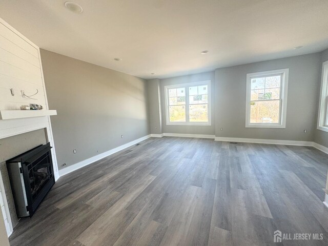 363 Ferris St, South Amboy, NJ 08879 - unfurnished living room with a wealth of natural light, a fireplace, dark wood-type flooring, and baseboards