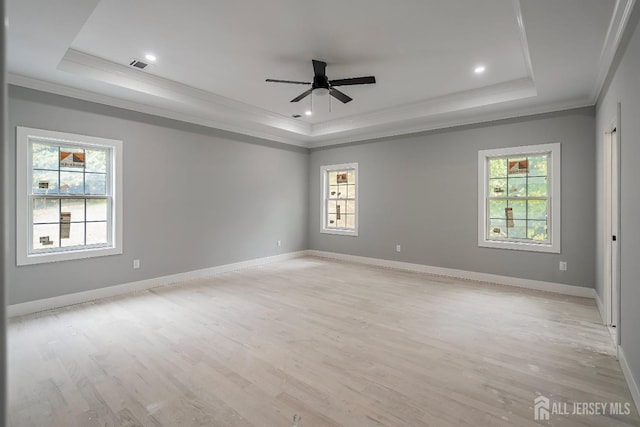 unfurnished room with a raised ceiling, ceiling fan, light wood-type flooring, and ornamental molding