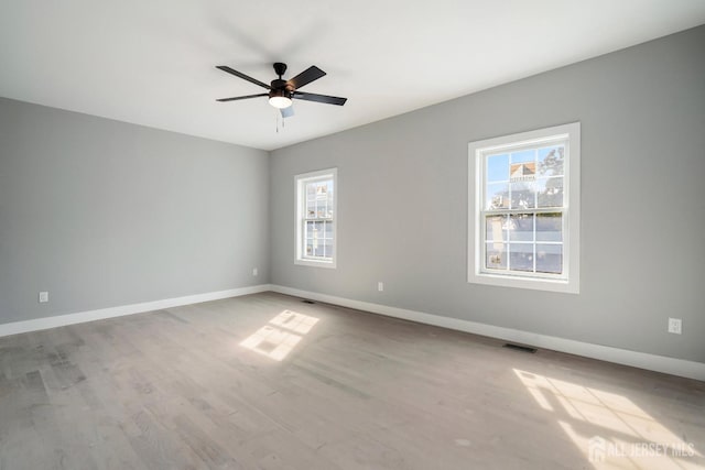 unfurnished room with wood-type flooring, plenty of natural light, and ceiling fan