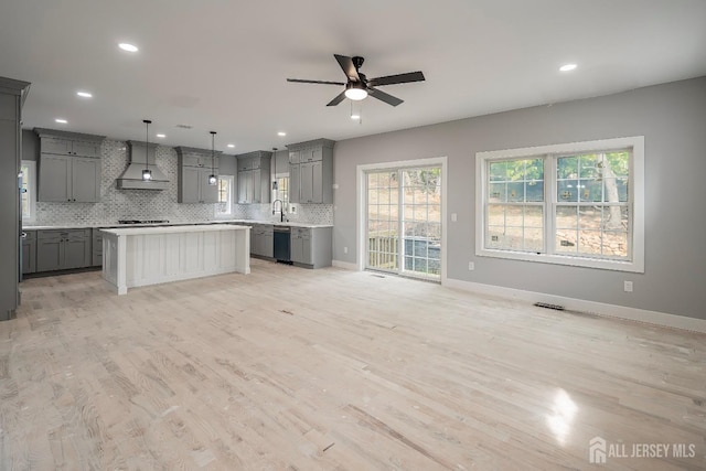 kitchen featuring custom exhaust hood, a center island, hanging light fixtures, stainless steel dishwasher, and gray cabinets