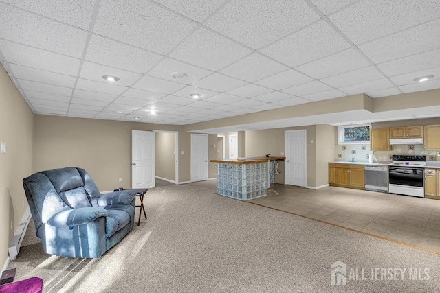 living room with bar, a drop ceiling, and light colored carpet