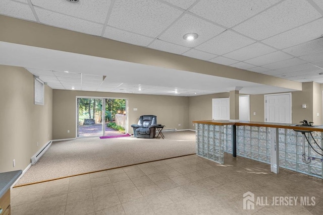 basement with light colored carpet, a drop ceiling, and a baseboard heating unit