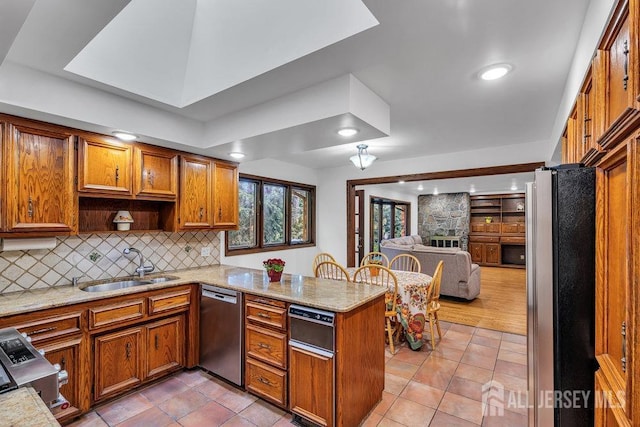 kitchen featuring stainless steel appliances, sink, light tile patterned floors, and kitchen peninsula