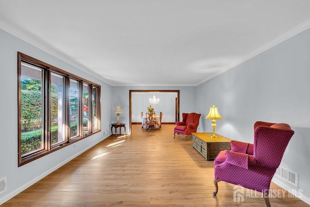 living area featuring ornamental molding and light hardwood / wood-style floors