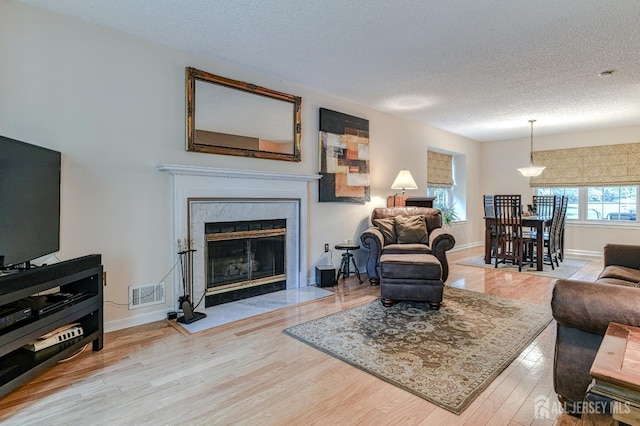 25 Sheffield Ct, North Brunswick, NJ 08902 - living room featuring wood finished floors, a textured ceiling, and a fireplace