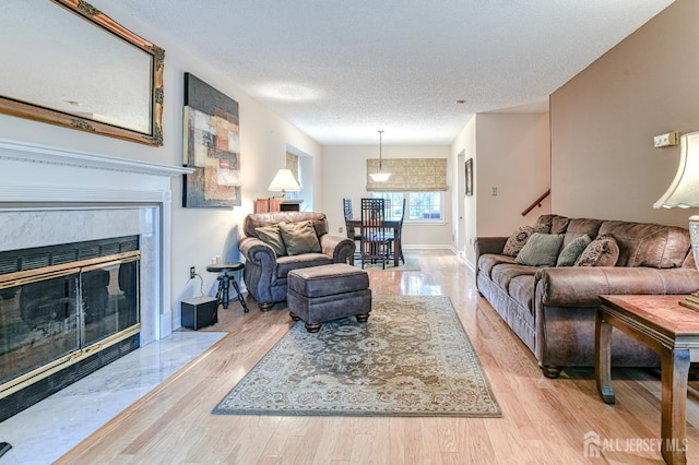 25 Sheffield Ct, North Brunswick, NJ 08902 - living area with wood finished floors, a textured ceiling, a high end fireplace, and stairs