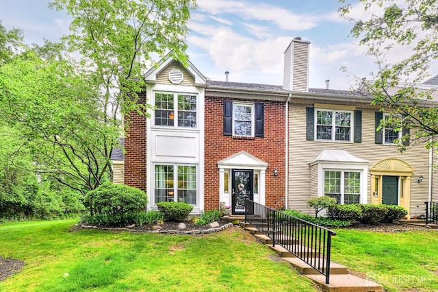 25 Sheffield Ct, North Brunswick, NJ 08902 - view of front of property featuring a front yard, a chimney, and brick siding