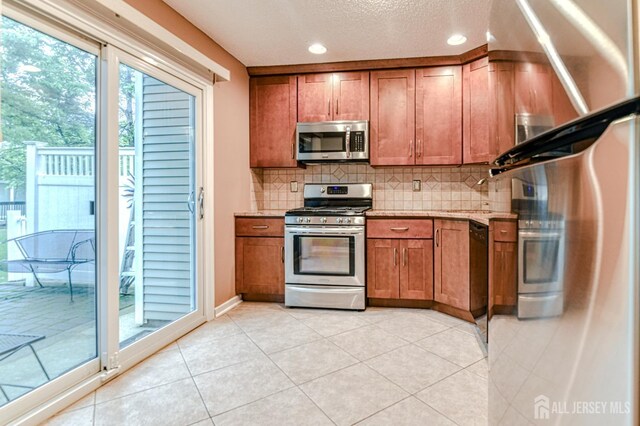 25 Sheffield Ct, North Brunswick, NJ 08902 - kitchen featuring appliances with stainless steel finishes, brown cabinets, backsplash, light tile patterned floors, and recessed lighting
