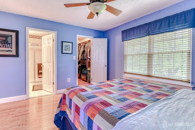 25 Sheffield Ct, North Brunswick, NJ 08902 - bedroom with a walk in closet, wood finished floors, a textured ceiling, a closet, and connected bathroom