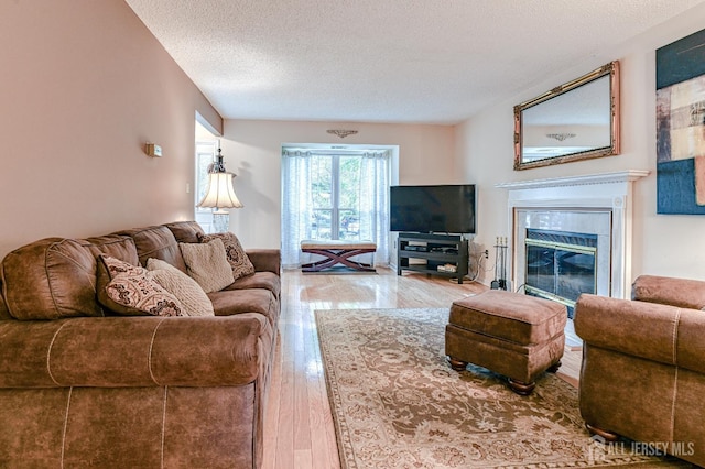 25 Sheffield Ct, North Brunswick, NJ 08902 - living room featuring hardwood / wood-style floors, a textured ceiling, and a tile fireplace