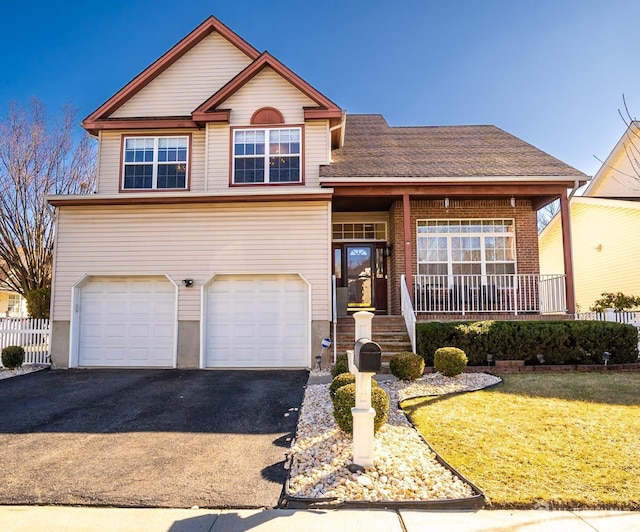 view of front of home with a porch, a garage, and a front lawn