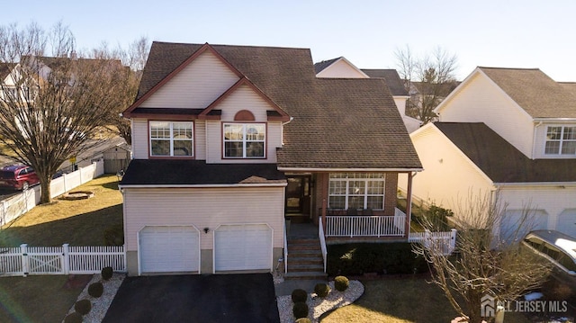 front of property featuring a garage, covered porch, and a front yard