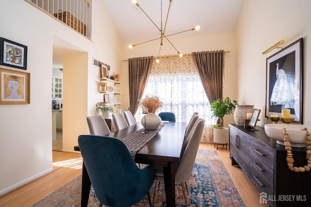 dining room featuring light hardwood / wood-style flooring and high vaulted ceiling