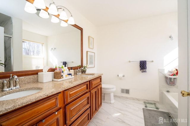 bathroom featuring vanity, toilet, and a notable chandelier