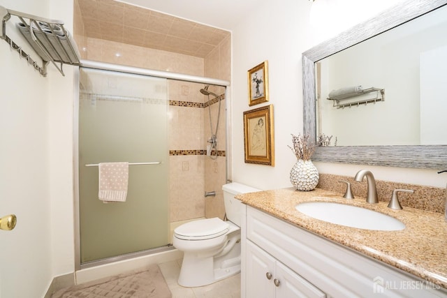 bathroom featuring vanity, toilet, a shower with shower door, and tile patterned flooring