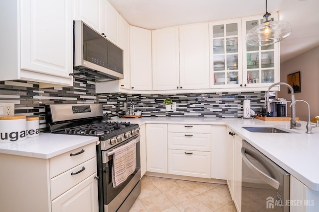 kitchen featuring appliances with stainless steel finishes, sink, pendant lighting, and white cabinets