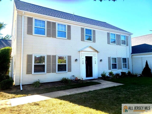 colonial-style house featuring a front lawn