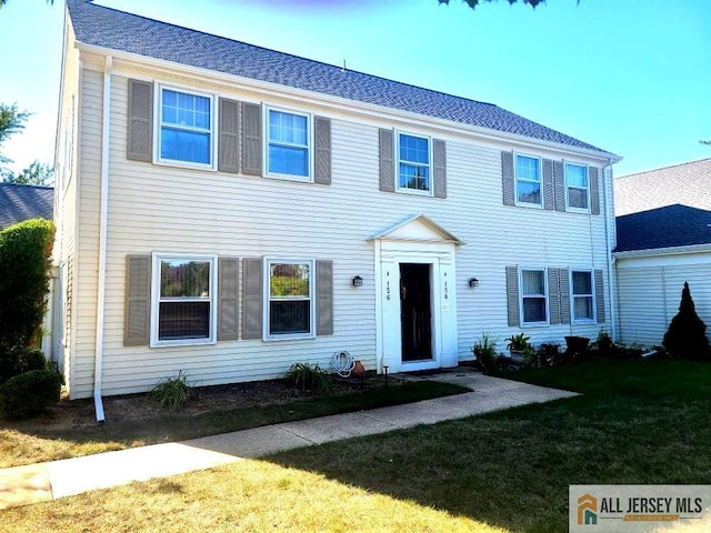 colonial home with a front lawn