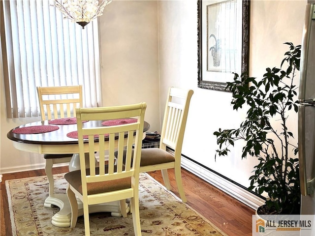 dining space with a notable chandelier and wood finished floors