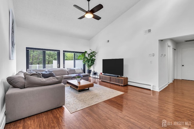 218 Community Cir, Old Bridge, NJ 08857 - living area featuring a baseboard radiator, high vaulted ceiling, a ceiling fan, wood finished floors, and baseboards