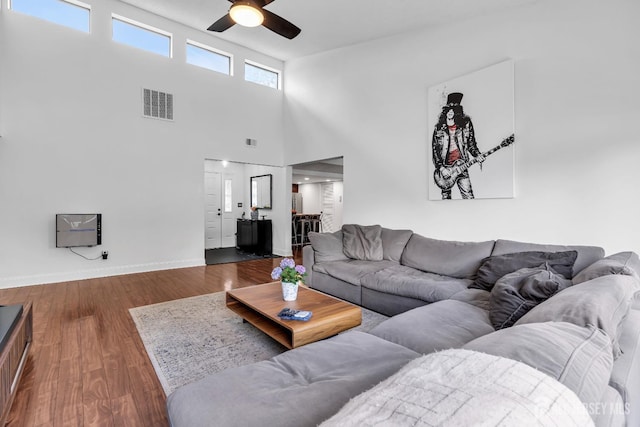 218 Community Cir, Old Bridge, NJ 08857 - living room featuring a ceiling fan, dark wood-style floors, baseboards, and a towering ceiling