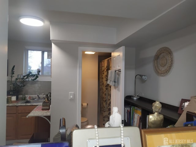 bathroom with a sink and decorative backsplash