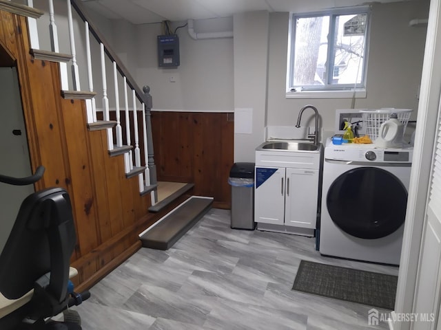 washroom featuring washer / dryer, cabinet space, and a sink