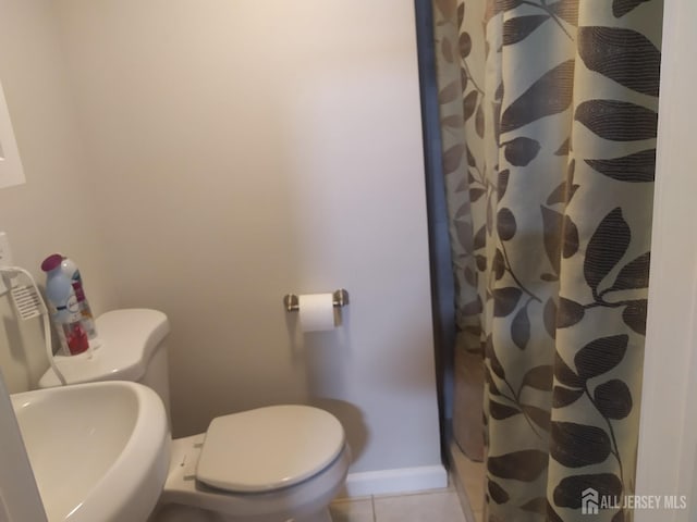 full bathroom with tile patterned flooring, baseboards, a sink, and toilet