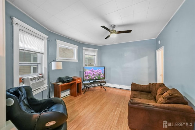 living area with crown molding, a baseboard radiator, light wood-style flooring, ceiling fan, and cooling unit