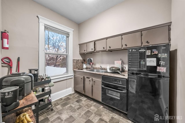 kitchen with light countertops, a sink, and black appliances