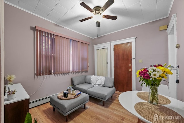 living room featuring a baseboard heating unit, light wood-style flooring, and crown molding