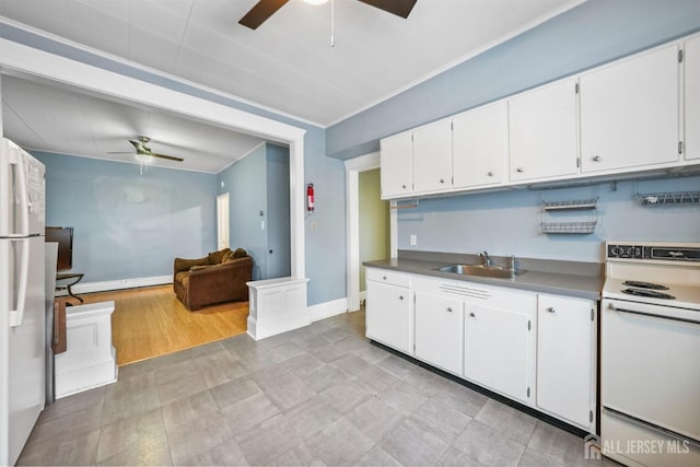 kitchen with dark countertops, a ceiling fan, white cabinetry, a sink, and white appliances