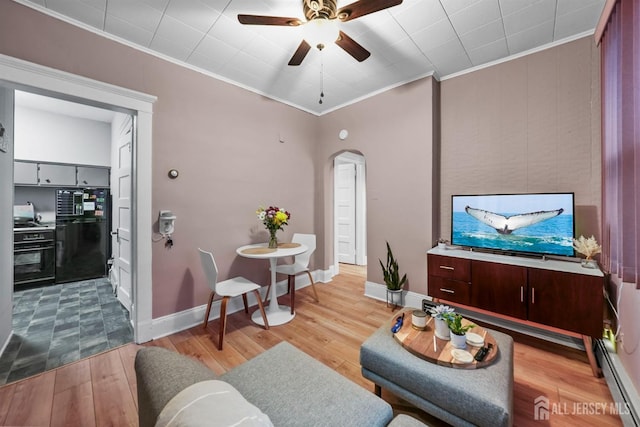 living area with arched walkways, crown molding, light wood-style flooring, and baseboard heating