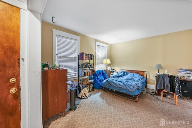 bedroom featuring baseboards and light colored carpet