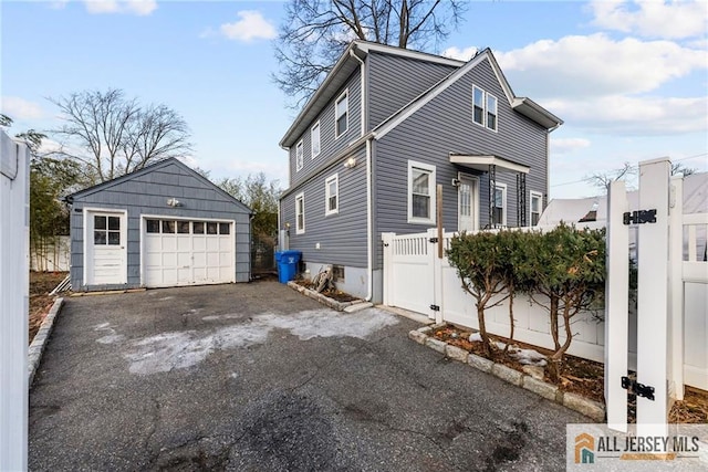 43 Livingston Ave, Avenel, NJ 07001 - view of side of home with a garage, an outbuilding, a gate, driveway, and fence
