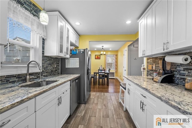 43 Livingston Ave, Avenel, NJ 07001 - kitchen featuring tasteful backsplash, stainless steel dishwasher, a sink, white cabinetry, and dark wood-type flooring