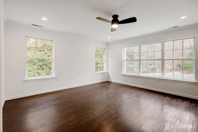 spare room with crown molding, dark wood finished floors, and visible vents