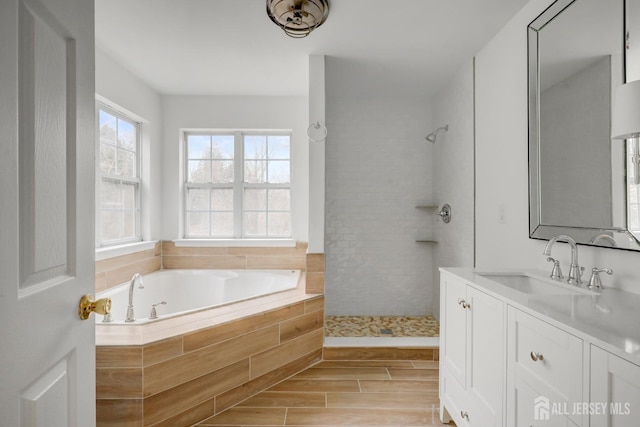 full bath featuring vanity, wood tiled floor, a garden tub, and a tile shower