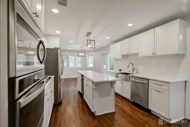kitchen featuring a sink, white cabinetry, visible vents, appliances with stainless steel finishes, and tasteful backsplash