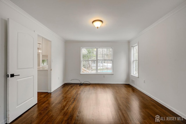empty room featuring baseboards, a wealth of natural light, and wood finished floors