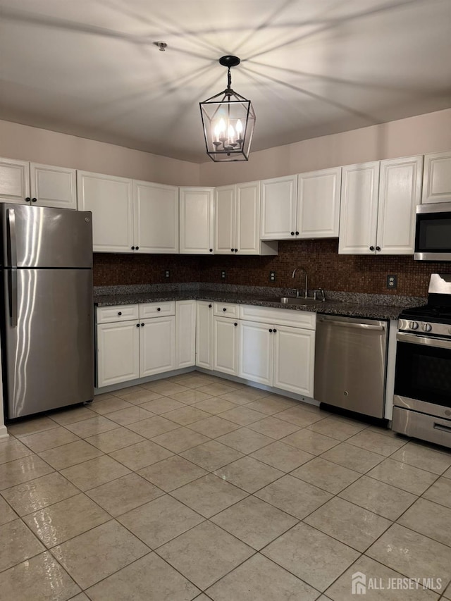 1057 Morning Glory Dr, Monroe, NJ 08831 - kitchen featuring appliances with stainless steel finishes, a sink, a chandelier, decorative backsplash, and white cabinetry