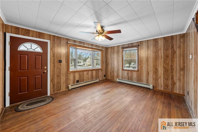 entryway featuring ornamental molding, a baseboard radiator, wood-type flooring, and baseboard heating