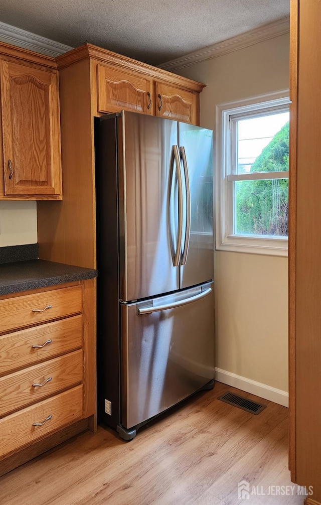 20 Brunswick Ave, Spotswood, NJ 08884 - kitchen with freestanding refrigerator, light wood-style floors, dark countertops, brown cabinets, and a textured ceiling