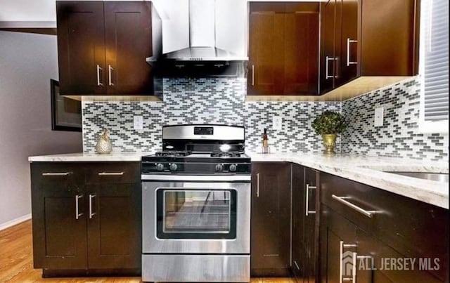 54 Washington Rd, Sayreville, NJ 08872 - kitchen with stainless steel gas range, wall chimney exhaust hood, light stone countertops, and dark brown cabinetry