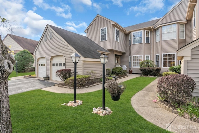 townhome / multi-family property with a shingled roof and a front yard