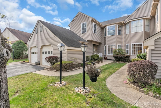 townhome / multi-family property with a garage and a front yard