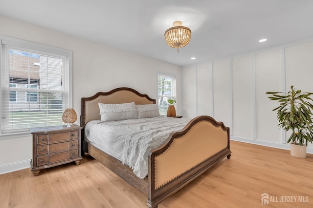 bedroom with light wood-type flooring, recessed lighting, a notable chandelier, and baseboards