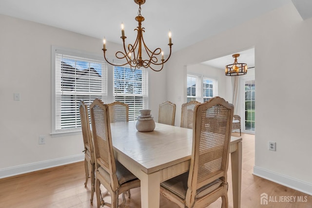 dining room featuring a chandelier, baseboards, and light wood-style flooring