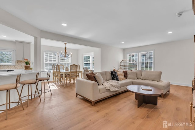 living room with recessed lighting, a chandelier, and light wood-style floors