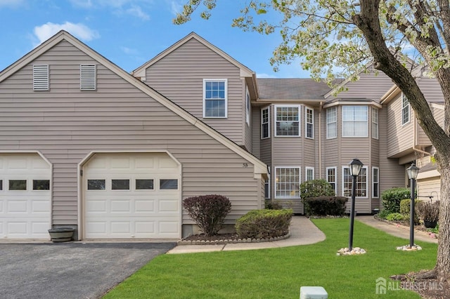 view of front facade with driveway, a front yard, and a garage